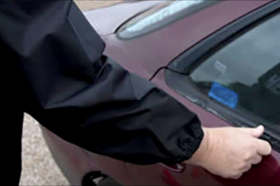 A person etches a VIN number onto a vehicle.